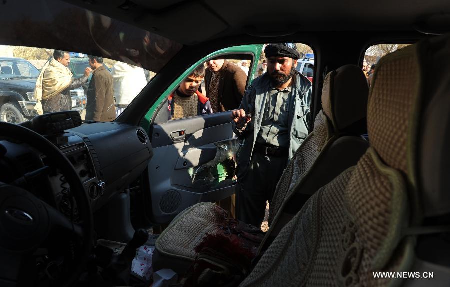 An Afghan policeman looks at a vehicle on which the police chief of Nimroz province Mohammad Musa Rasouli was killed in Herat, Afghanistan, on Dec. 10, 2012. The police chief was killed Monday in a blast in the neighboring Herat province, a police spokesman said. (Xinhua/Sardar) 