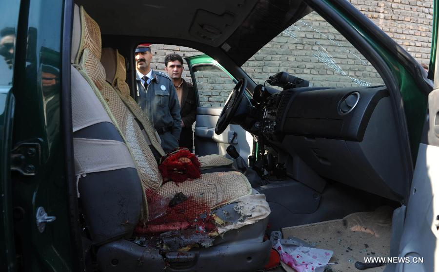 Afghan policemen stand near a vehicle on which the police chief of Nimroz province Mohammad Musa Rasouli was killed in Herat, Afghanistan, on Dec. 10, 2012. The police chief was killed Monday in a blast in the neighboring Herat province, a police spokesman said. (Xinhua/Sardar) 