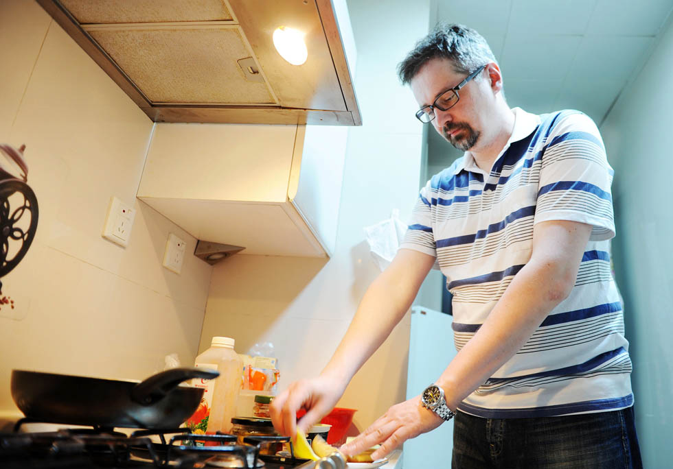 Anatoly Burov cooks supper at home in Shanghai, east China, May 6, 2012. (Xinhua/Lai Xinlin) 