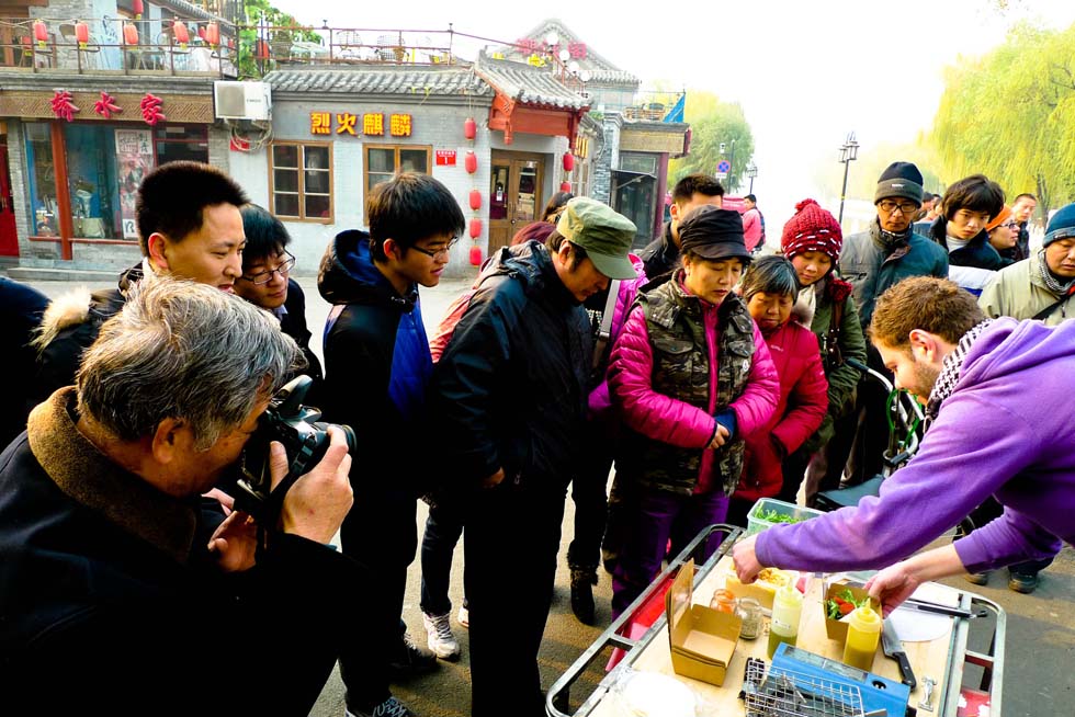 Jamie (R, Front) makes "pitta and hummus", an Arab snack, in Shichahai, a historic scenic area in Beijing, capital of China, Dec. 1, 2011.(Xinhua/Zhang Ruiqi)