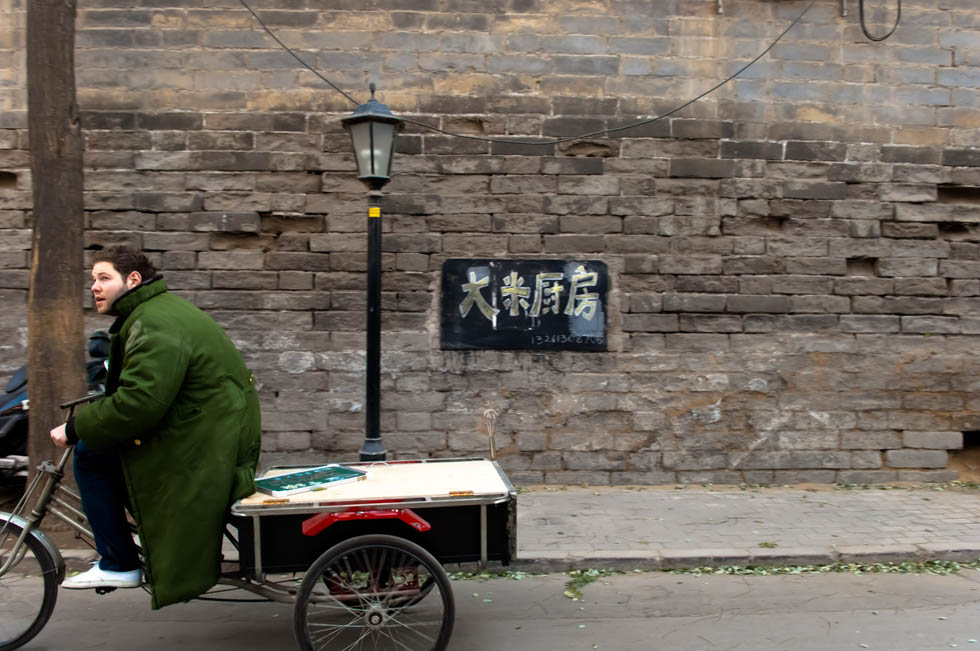 Wheeling his souped-up tricycle that serves as a mobile snack stand, Jamie sets off for business from his residence near Shichahai, a historic scenic area in Beijing, capital of China, Dec. 7, 2011. (Xinhua/Liu Jinhai)