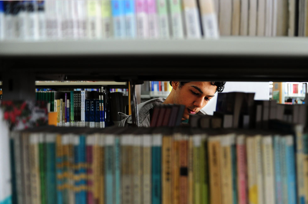 Mustafaal Share'a from Jordan looks through books in the library of Shenyang Normal University in Shenyang, capital of northeast China's Liaoning Province, Sept. 15, 2012.(Xinhua/Yang Qing) 