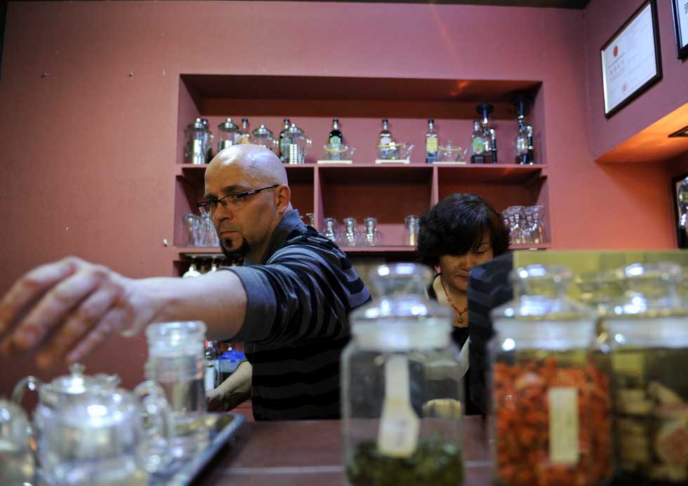 Kevin Gilley (L) and a waitress work at his cafe in Dunhuang, northwest China's Gansu Province, April 29, 2012. 