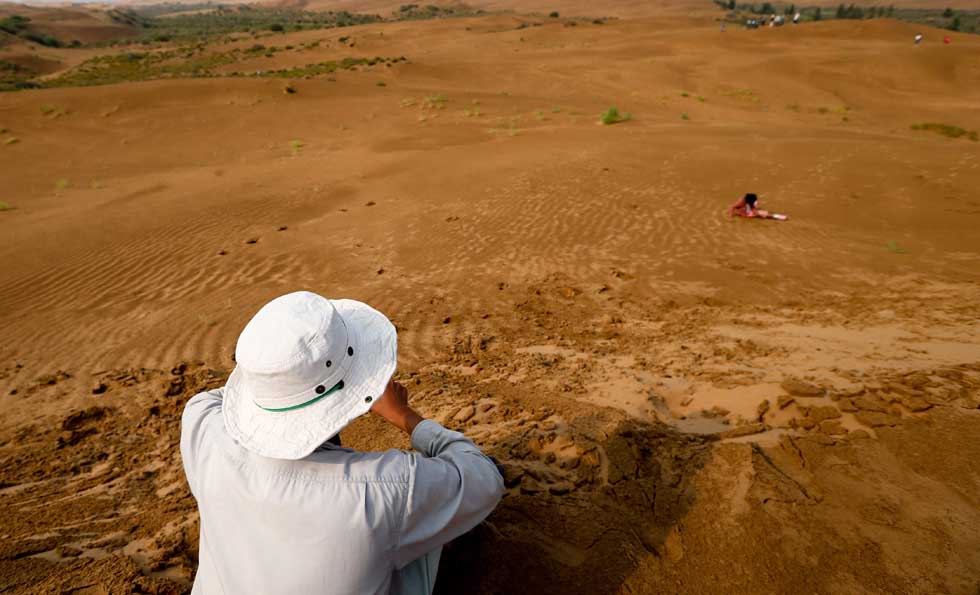 Mase Hiroki takes a rest on a sand dune in Engebei, Ordos, north China's Inner Mongolia Autonomous Region, Aug. 26, 2012.(Xinhua/Xie Xiudong)