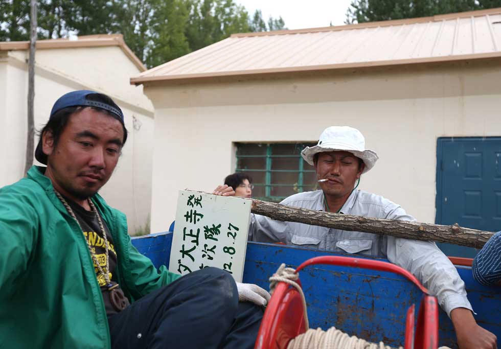 Mase Hiroki (R) and Tanabe Hidenori prepare to go to a planting tree area in Engebei, Ordos, north China's Inner Mongolia Autonomous Region, Aug. 25, 2012.