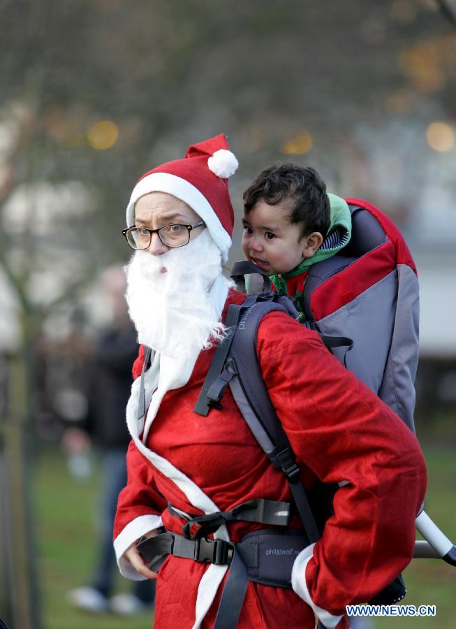 A woman dressed as Santa Claus takes part in the "Santa run" at Greenwich Park in London, Britain, on Dec. 9, 2012. (Xinhua/Bimal Gautam) 