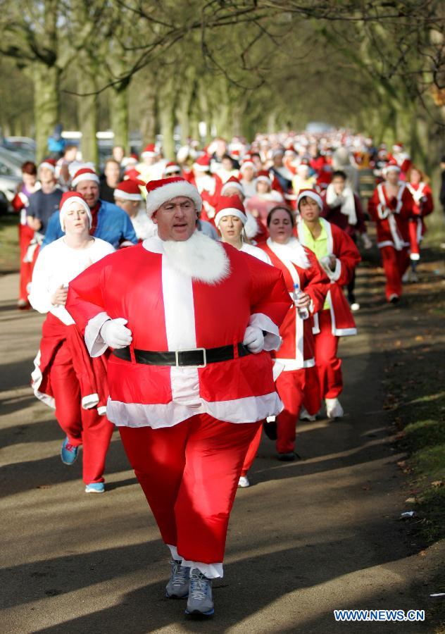 People dressed as Santa Claus take part in the "Santa run" at Greenwich Park in London, Britain, on Dec. 9, 2012. (Xinhua/Bimal Gautam) 