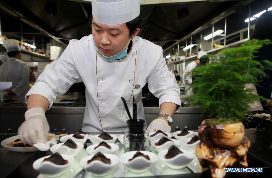 A cook creats dishes during a culinary contest in Neijiang, southwest China's Sichuan Province, Dec. 10, 2012. A total of 16 cooks attended the contest held here on Monday. (Xinhua/Lan Zitao) 