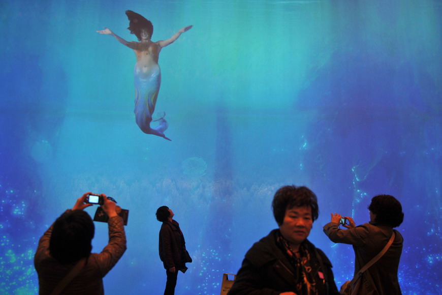 Tourists from China take photos for “Mermaid” in “Dreams of City” shopping mall in Macao on Feb 24, 2012.  (AFP/ Aaron Tam)