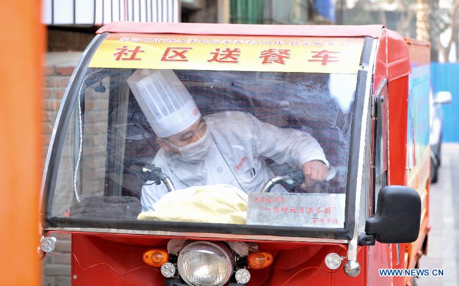 A community catering staff prepares at a food truck in Donggaodi sub-district of south Beijing, capital of China, Dec. 11, 2012. Local sub-district office took measures and established 4 community dining rooms and 3 food trucks serving the aged citizens exclusively. Around 2,000 senior citizens benefited from the convenience-for-people measures since 2011. (Xinhua/Li Xin) 