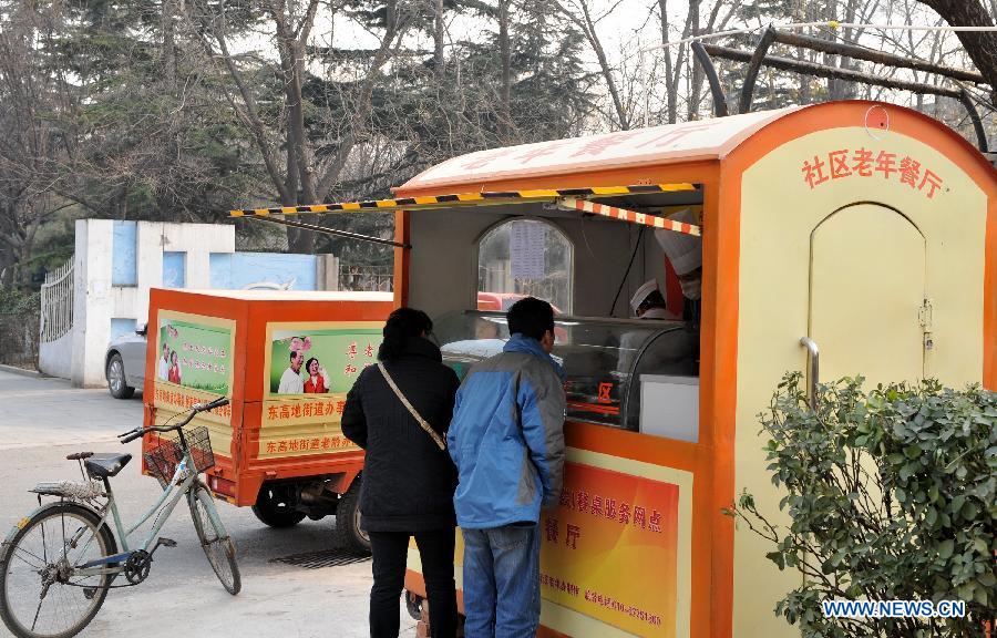 Residents buy meal at a community food truck in Donggaodi sub-district of south Beijing, capital of China, Dec. 11, 2012. Local sub-district office took measures and established 4 community dining rooms and 3 food trucks serving the aged citizens exclusively. Around 2,000 senior citizens benefited from the convenience-for-people measures since 2011. (Xinhua/Li Xin) 