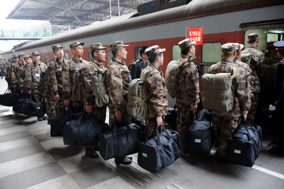 New recruits for the People's Liberation Army wait for the train to leave at a train station. The People's Liberation Army has launched its annual winter conscription this year. (Xinhua)