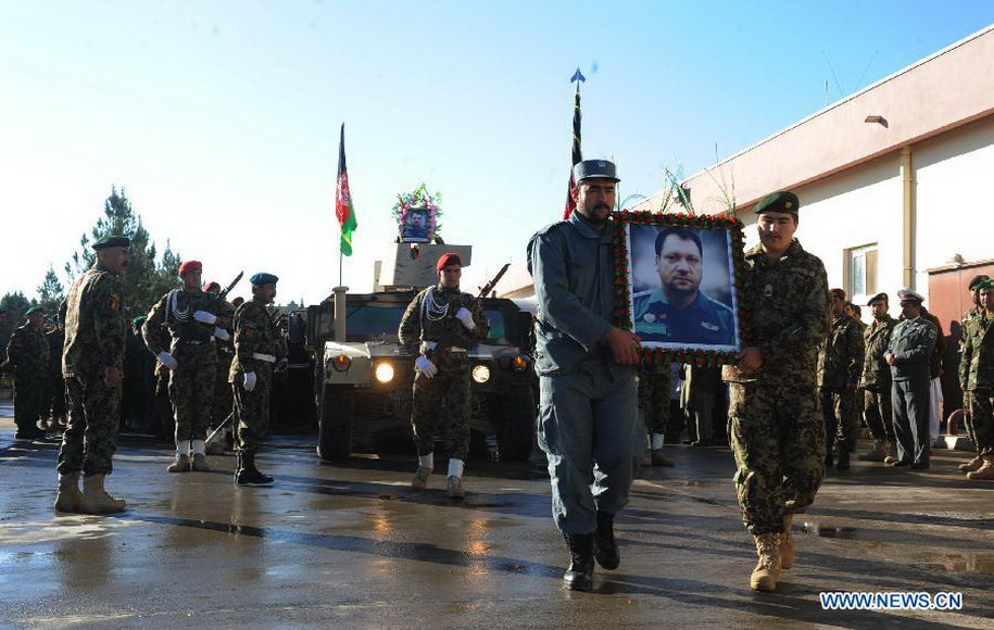 Afghan soldiers march with a portrait of Mohammad Musa Rasouli, the provincial police chief of Afghanistan's southwestern province of Nimroz, during his funeral in Herat province, west of Afghanistan, on Dec. 11, 2012. (Xinhua/Sardar)