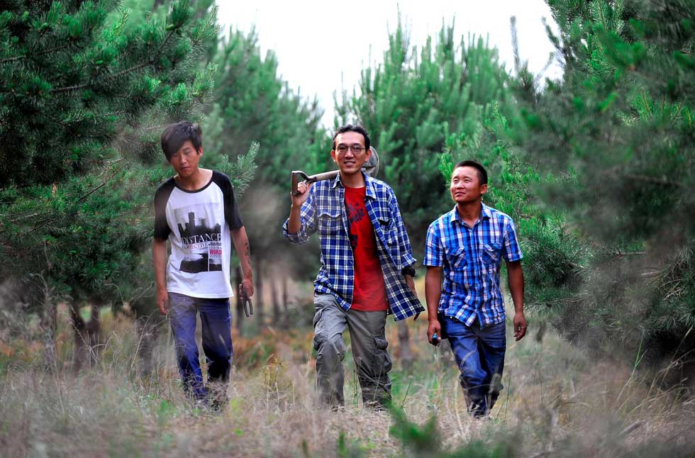 Otaki Takashi (C) walks with members of Green Network in a forest planted by them in Kulun Banner of Tongliao City, north China's Inner Mongolia Autonomous Region, June 11, 2012.(Xinhua/Ren Junchuan)