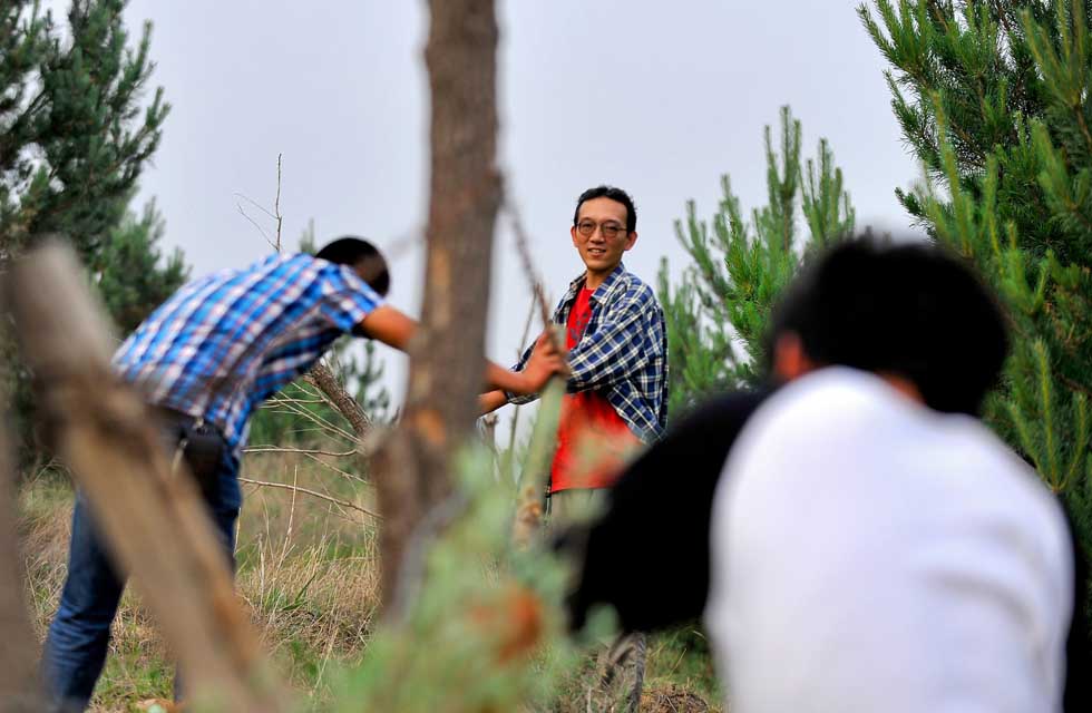 Otaki Takashi (C) works with members of Green Network in Kulun Banner of Tongliao City, north China's Inner Mongolia Autonomous Region, June 11, 2012. (Xinhua/Ren Junchuan)