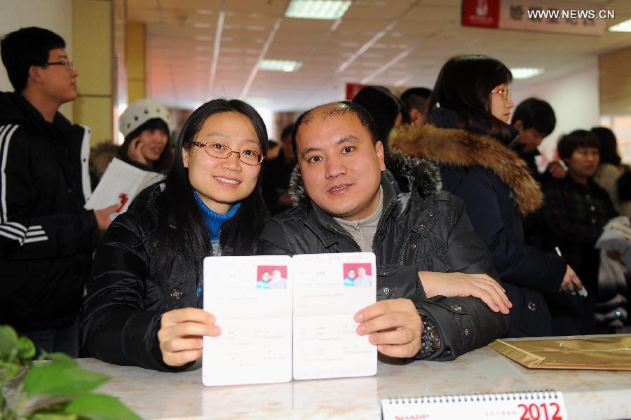 A young couple show their marriage certificates at a civil affairs bureau in Changchun, capital of northeast China's Jilin Province, Dec. 12, 2012. Young couples across the country rushed to get married on Dec, 12, 2012, or 12/12/12, hoping that the "triple 12 day" will bring them good luck. In Chinese, the number 12 is pronounced like "Yao Ai", meaning "To Love" in English. (Xinhua/Lin Hong)