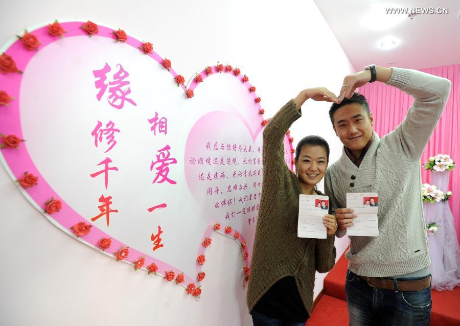 A young couple show their marriage certificates at a civil affairs bureau in Suzhou City, east China's Jiangsu Province, Dec. 12, 2012. Young couples across the country rushed to get married on Dec, 12, 2012, or 12/12/12, hoping that the "triple 12 day" will bring them good luck. In Chinese, the number 12 is pronounced like "Yao Ai", meaning "To Love" in English. (Xinhua/Hang Xingwei)