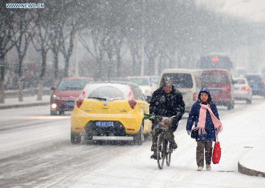 Citizens make their way in snow in Tiantongyuan, Beijing, capital of China, Dec. 12, 2012. A snow hit China's capital city on Wednesday. (Xinhua/Yin Bogu) 