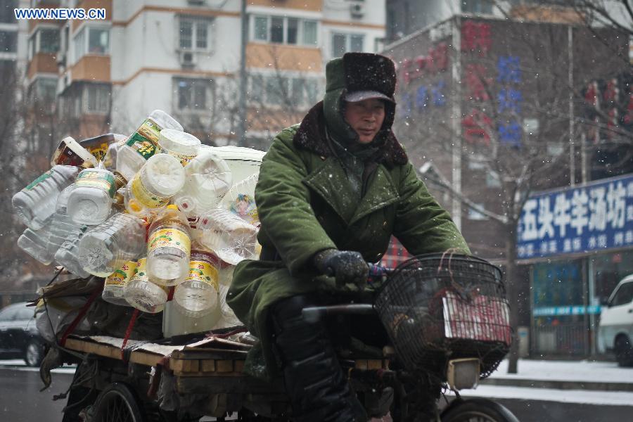 A waste collector rides in snow in Shijingshan District, Beijing, capital of China, Dec. 12, 2012. A snow hit China's capital city on Wednesday. (Xinhua/Zheng Huansong)