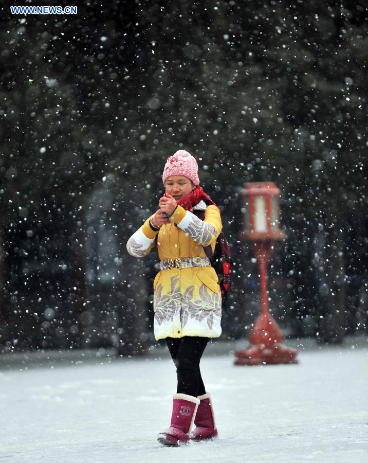 A visitor tours the Tiantan Park in snow in Beijing, capital of China, Dec. 12, 2012. A snow hit China's capital city on Wednesday. (Xinhua/Li Wen)