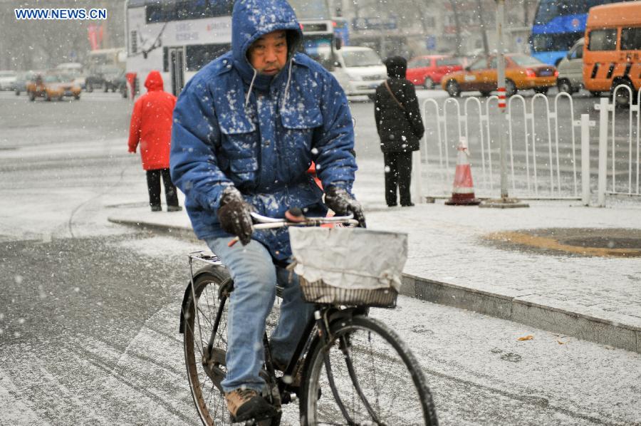 A man rides bicycle in snow in Beijing, capital of China, Dec. 12, 2012. A snow hit China's capital city on Wednesday. (Xinhua/Sun Ruibo)