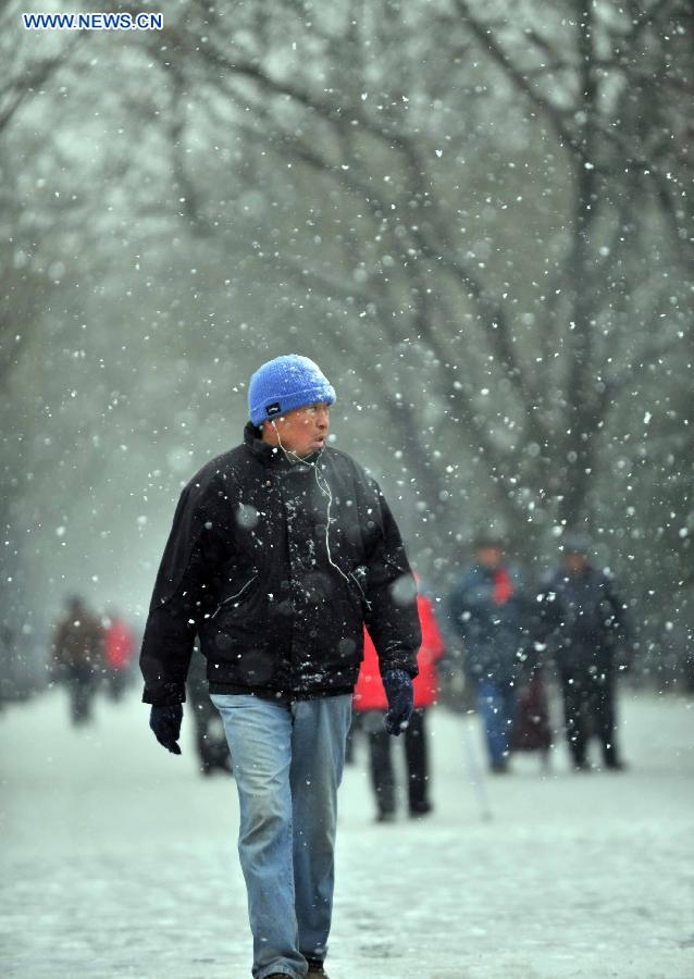 A man tours the Tiantan Park in snow in Beijing, capital of China, Dec. 12, 2012. A snow hit China's capital city on Wednesday. (Xinhua/Li Wen) 