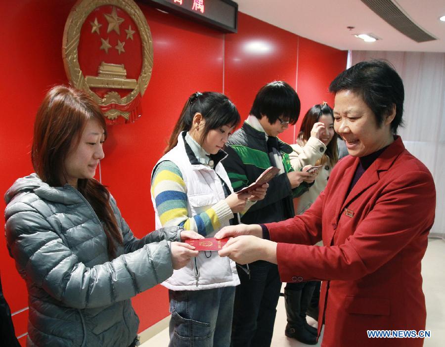 Couples receive their marriage certificates in Shanghai, east China, Dec. 12, 2012. Chinese couples rushed to tie the knot on Wednesday, believing the day to be an auspicious one, as the date sounds like a promise of love when said in Chinese. (Xinhua/Ding Ding)