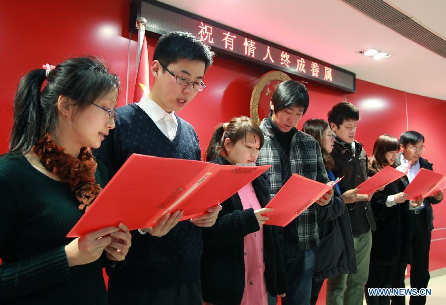 Couples read marriage vows in Shanghai, east China, Dec. 12, 2012. Chinese couples rushed to tie the knot on Wednesday, believing the day to be an auspicious one, as the date sounds like a promise of love when said in Chinese. (Xinhua/Ding Ding)