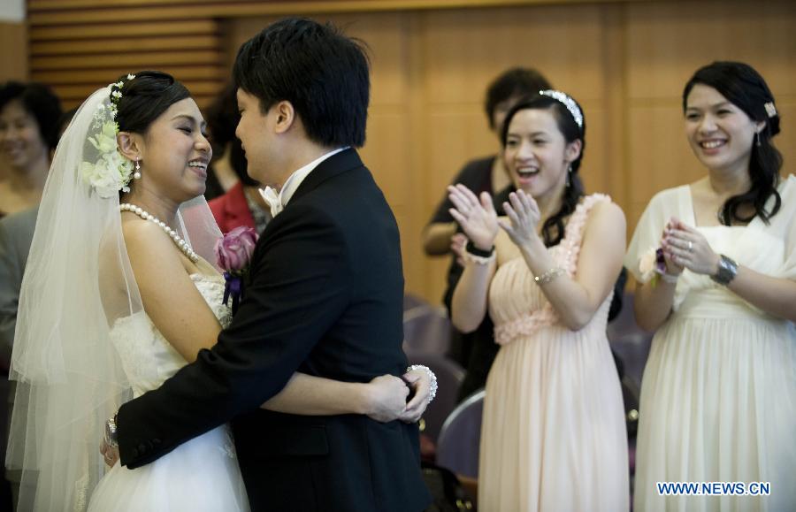 A groom and his bride hug at their wedding in Hong Kong, south China, Dec. 12, 2012. A total of 696 couples flocked to tie the knot on Dec. 12, 2012, or 12/12/12, which sounds like "will love/will love/will love" in Chinese. (Xinhua/Lui Siu Wai)