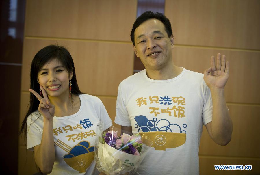 A couple poses for a photo after registering as married at 12 o'clock in Hong Kong, south China, Dec. 12, 2012. A total of 696 couples flocked to tie the knot on Dec. 12, 2012, or 12/12/12, which sounds like "will love/will love/will love" in Chinese. (Xinhua/Lui Siu Wai)