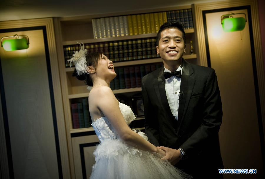 A couple is seen at the marriage registration hall in Hong Kong, south China, Dec. 12, 2012. A total of 696 couples flocked to tie the knot on Dec. 12, 2012, or 12/12/12, which sounds like "will love/will love/will love" in Chinese. (Xinhua/Lui Siu Wai)