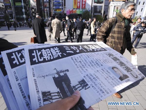 A staff member of the Asahi Shimbun delivers the extra of the newspaper with reports about the rocket launch by the Democratic People's Republic of Korea (DPRK), in Tokyo, Japan, Dec. 12, 2012. The DPRK on Wednesday successfully launched and orbited a Kwangmyongsong-3 satellite, the official news agency KCNA reported. (Xinhua/Kenichiro Seki)