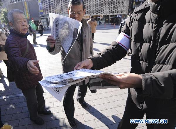 A staff member of the Asahi Shimbun delivers the extra of the newspaper with reports about the rocket launch by the Democratic People's Republic of Korea (DPRK), in Tokyo, Japan, Dec. 12, 2012. The DPRK on Wednesday successfully launched and orbited a Kwangmyongsong-3 satellite, the official news agency KCNA reported. (Xinhua/Kenichiro Seki)