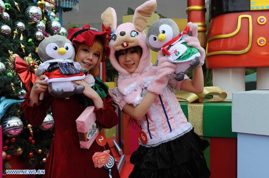 Girls dressed as cartoon characters pose for photo during Christmas party at the Ocean Park in Hong Kong, south China, Dec. 11, 2012. (Xinhua/Zhao Yusi)