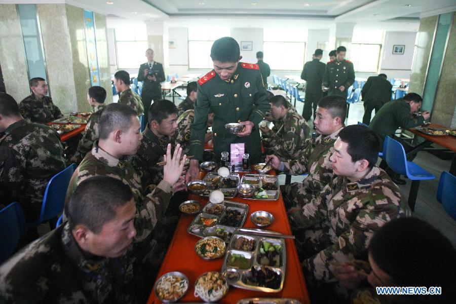 Newly recruited para-military policemen have lunch at a para-military policemen base in Hohhot, north China's Inner Mongolia Autonomous Region, Dec. 12, 2012. Newly recruited soldiers of People's Liberation Army (PLA) joined their army units around the country recently. (Xinhua/Zhang Fan)