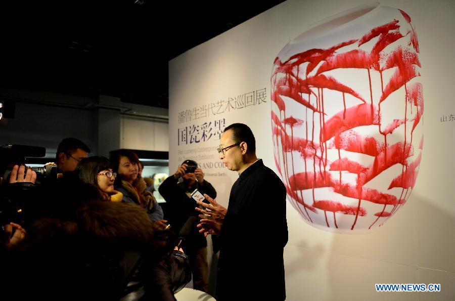 Chinese artist Pan Lusheng (R) speaks to journalists at his solo art exhibition in Shandong Museum in Jinan, capital of east China's Shandong Province, Dec. 12, 2012. Nearly 100 pieces of porcelain artworks by Pan were displayed at the exhibition which kicked off on Wednesday. (Xinhua/Zhu Zheng)