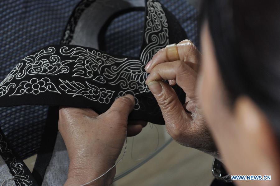 Wei Taohua, a horse-tail embroidery craftswoman of Shui ethnic group, embroiders in Sandu, southwest China's Guizhou Province, Dec. 12, 2012. (Xinhua/Ou Dongqu)