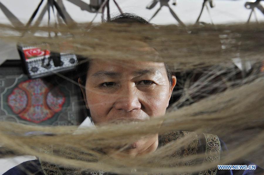 Wei Taohua, horse-tail embroidery craftswoman of Shui ethnic group, picks horsetail hairs in Sandu, southwest China's Guizhou Province, Dec. 12, 2012. (Xinhua/Ou Dongqu)