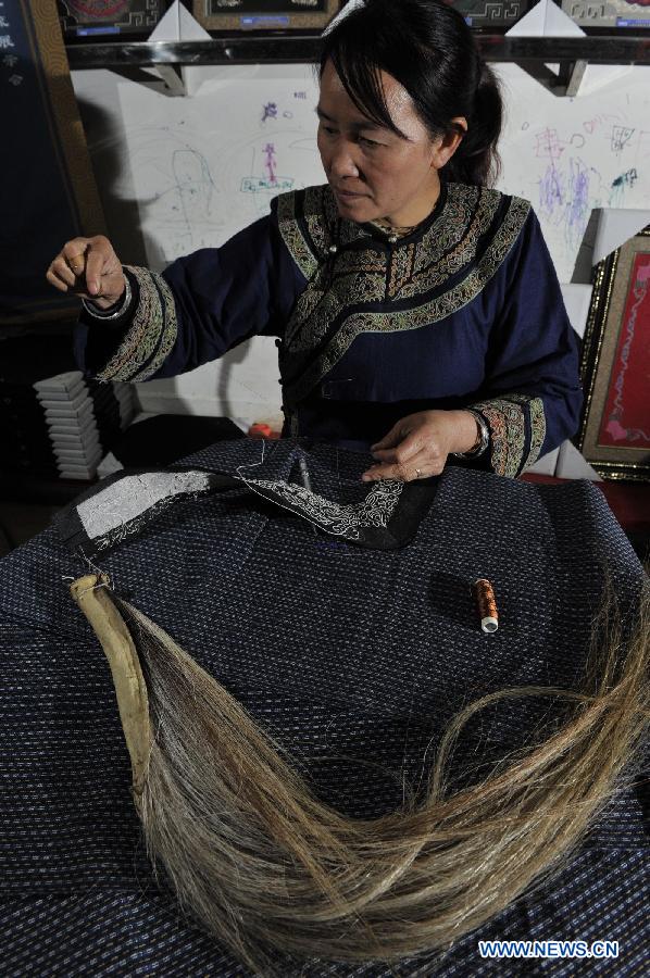 Wei Taohua, a horse-tail embroidery craftswoman of Shui ethnic group, embroiders in Sandu, southwest China's Guizhou Province, Dec. 12, 2012. (Xinhua/Ou Dongqu)