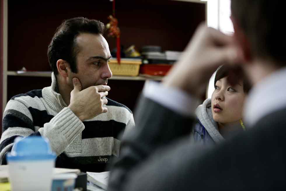 Peyam (L), president of Smile English School, reacts during a discussion on teaching with teachers at his school in Yinchuan, capital of northwest China's Ningxia Hui Autonomous Region, March 15, 2012.(Xinhua/Zheng Huansong)