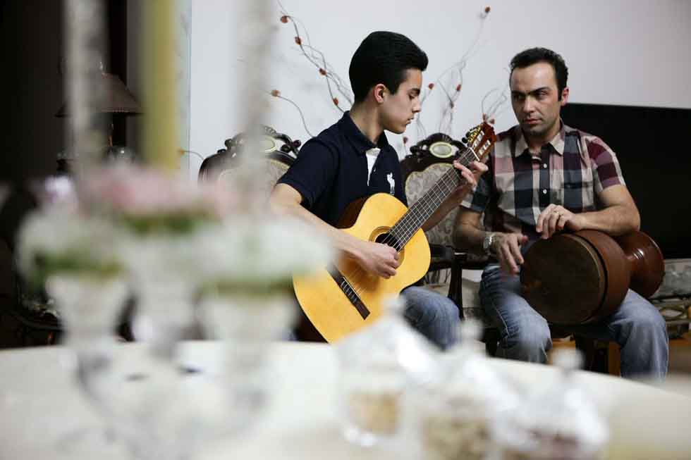 Peyam and his son Bai Yun play musical instruments at their home in Yinchuan, capital of northwest China's Ningxia Hui Autonomous Region, March 15, 2012.(Xinhua/Zheng Huansong)