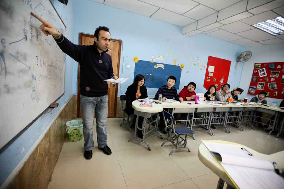 Peyam (1st L), president of Smile English School, trains teachers at his school in Yinchuan, capital of northwest China's Ningxia Hui Autonomous Region, March 14, 2012.(Xinhua/Zheng Huansong)