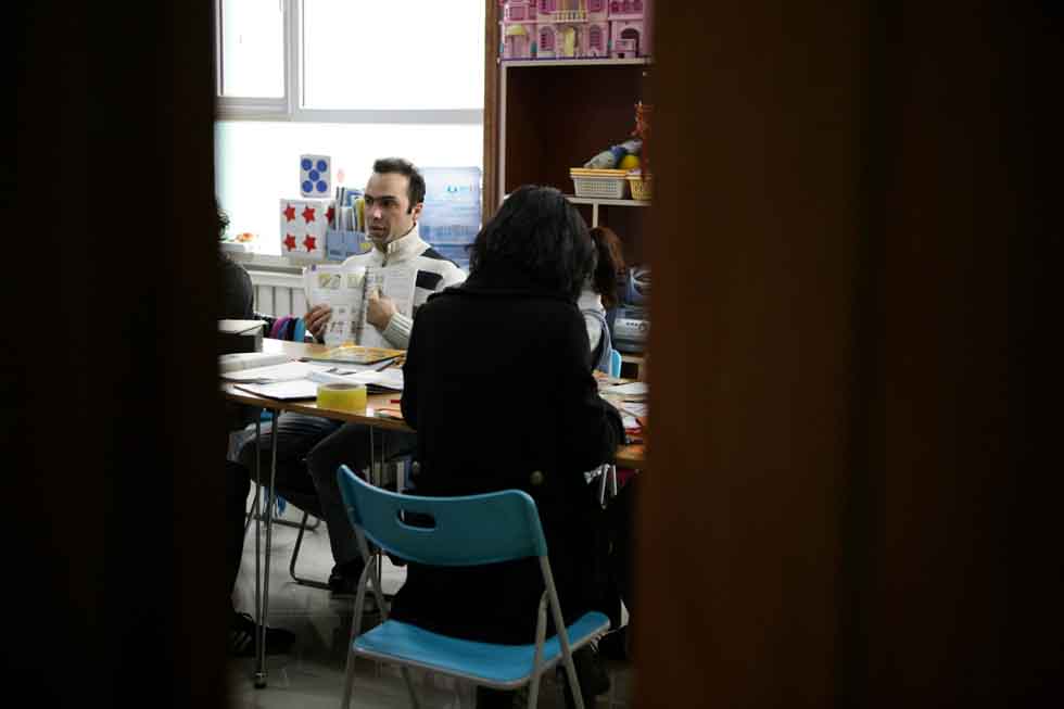 Peyam (L), president of Smile English School, has a discussion with colleagues in a meeting on teaching at his school in Yinchuan, capital of northwest China's Ningxia Hui Autonomous Region, March 15, 2012.(Xinhua/Zheng Huansong)