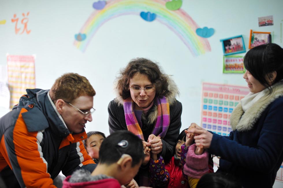 Uwe Brutzer (1st R) and his wife Dorothee Brutzer (C) help deaf-mute children do rehabilitation exercise at a training center in Changsha, capital of central China's Hunan Province, Feb. 21, 2012. (Xinhua/Bai Yu)