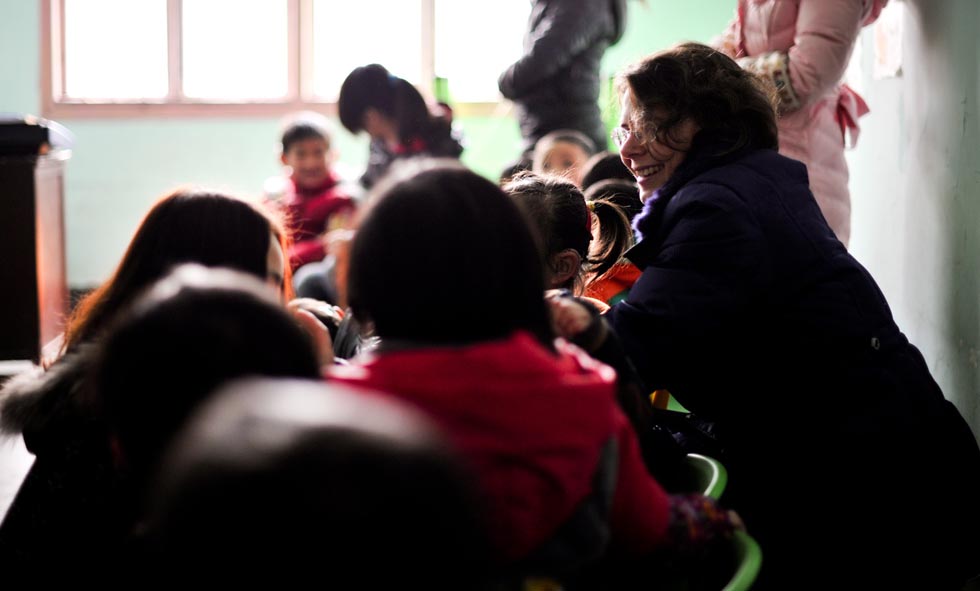 Dorothee Brutzer (R) communicates with deaf-mute children at a rehabilitation training center in Changsha, capital of central China's Hunan Province, Feb. 8, 2012. (Xinhua/Bai Yu)