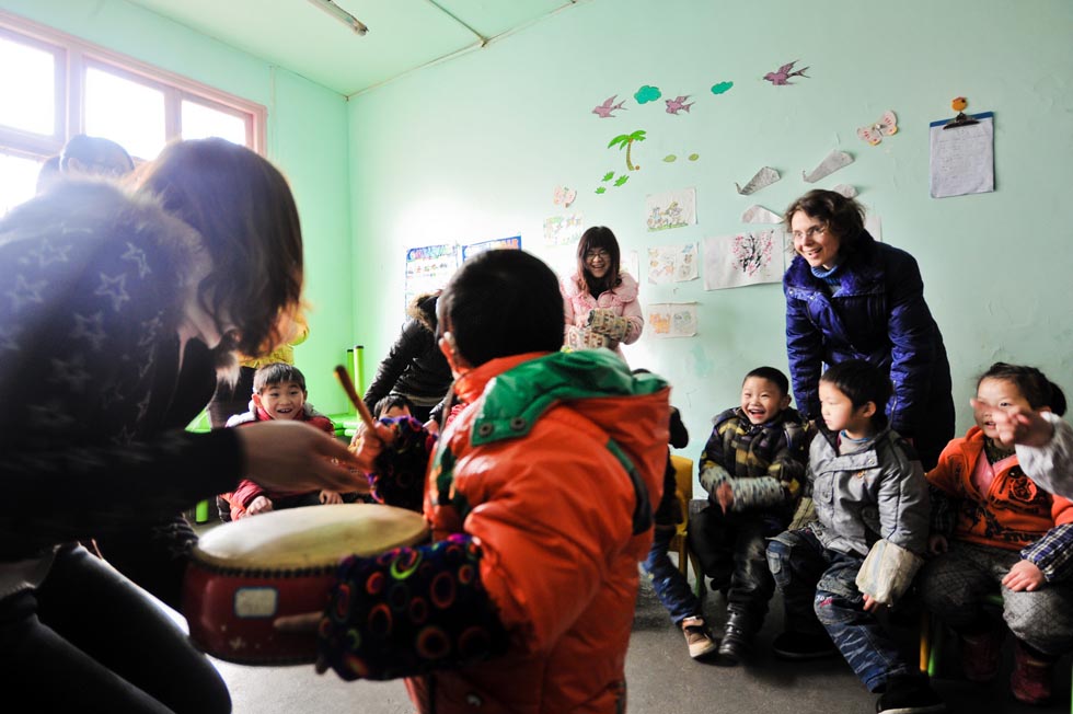 Dorothee Brutzer (R, standing) attends the class for deaf-mute children at a rehabilitation training center in Changsha, capital of central China's Hunan Province, Feb. 8, 2012.(Xinhua/Bai Yu)