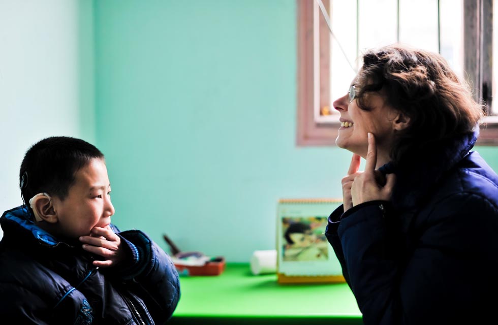 Dorothee Brutzer (R) gives language training for a hearing impaired boy at a rehabilitation training center in Changsha, capital of central China's Hunan Province, Feb. 8, 2012. (Xinhua/Bai Yu)