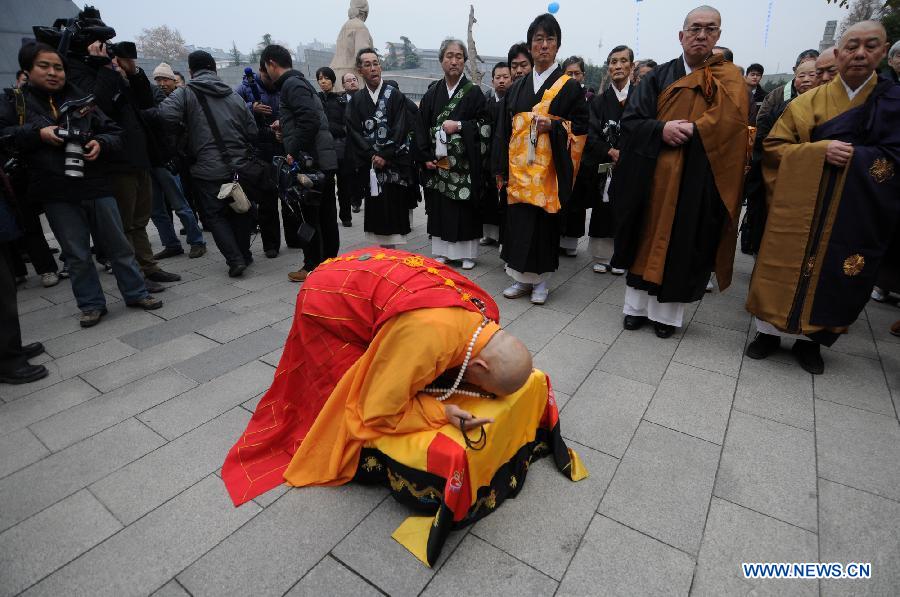 A Buddhist monk from Nanjing's Pilu Temple chants mantras for Nanjing Massacre victims at a religious service at the Memorial Hall of the Victims in Nanjing Massacre by Japanese Invaders in Nanjing, capital of east China's Jiangsu Province, Dec. 13, 2012, to mark the 75th anniversary of the Nanjing Massacre.(Xinhua/Shen Peng)