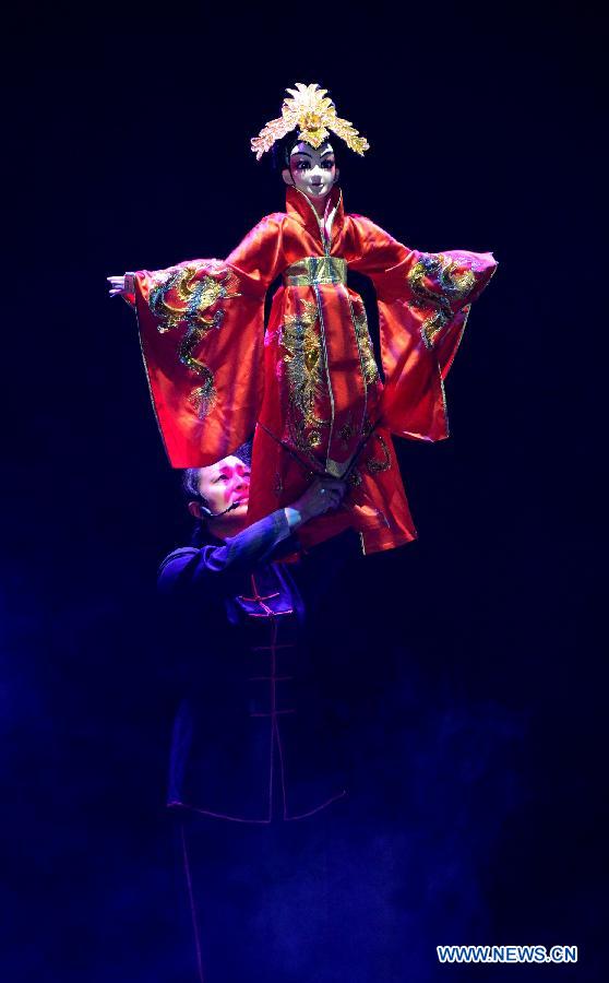 An artist controls a puppet during the 4th national puppet show and shadow play competition in Xi'an, capital of northwest China's Shaanxi Province, Dec. 13, 2012. Sixteen team from the nation would perform 51 shows during the competition.(Xinhua/Li Yibo)