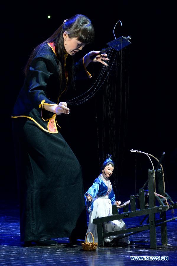 An artist controls a puppet during the 4th national puppet show and shadow play competition in Xi'an, capital of northwest China's Shaanxi Province, Dec. 13, 2012. Sixteen team from the nation would perform 51 shows during the competition.(Xinhua/Li Yibo)